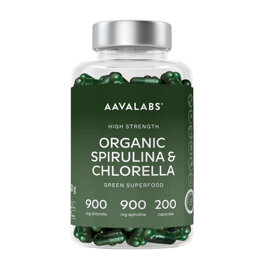 A clear plastic bottle of Aavalabs Organic Spirulina & Chlorella green superfood capsules, featuring a dark green label and a silver cap, filled with dark green capsules against a white background.